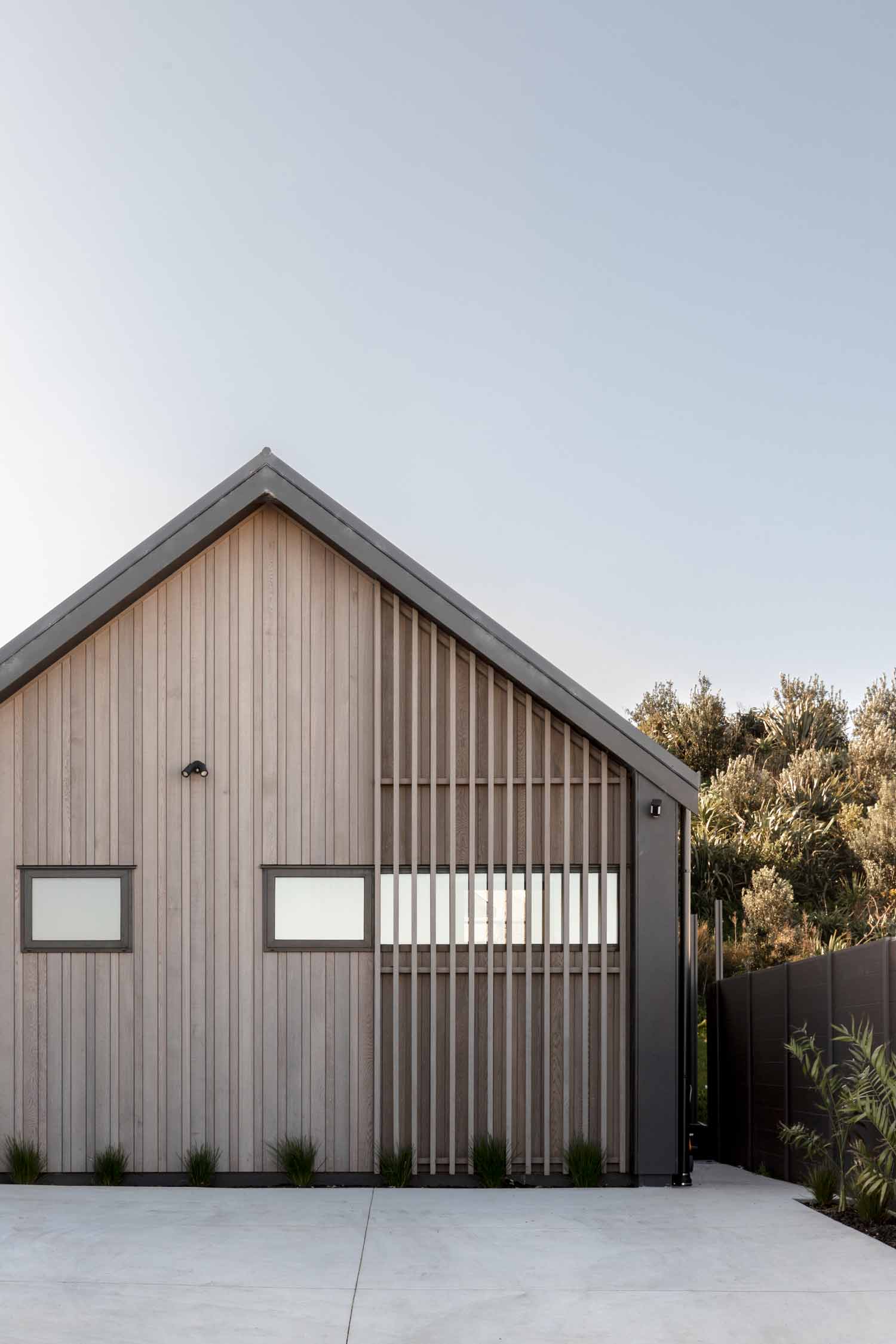 New-Zealand-architecture-of-an-industrial-style-contempory-home-features-timber-cladding-and-vertical-privacy-screen-and-dark-trim