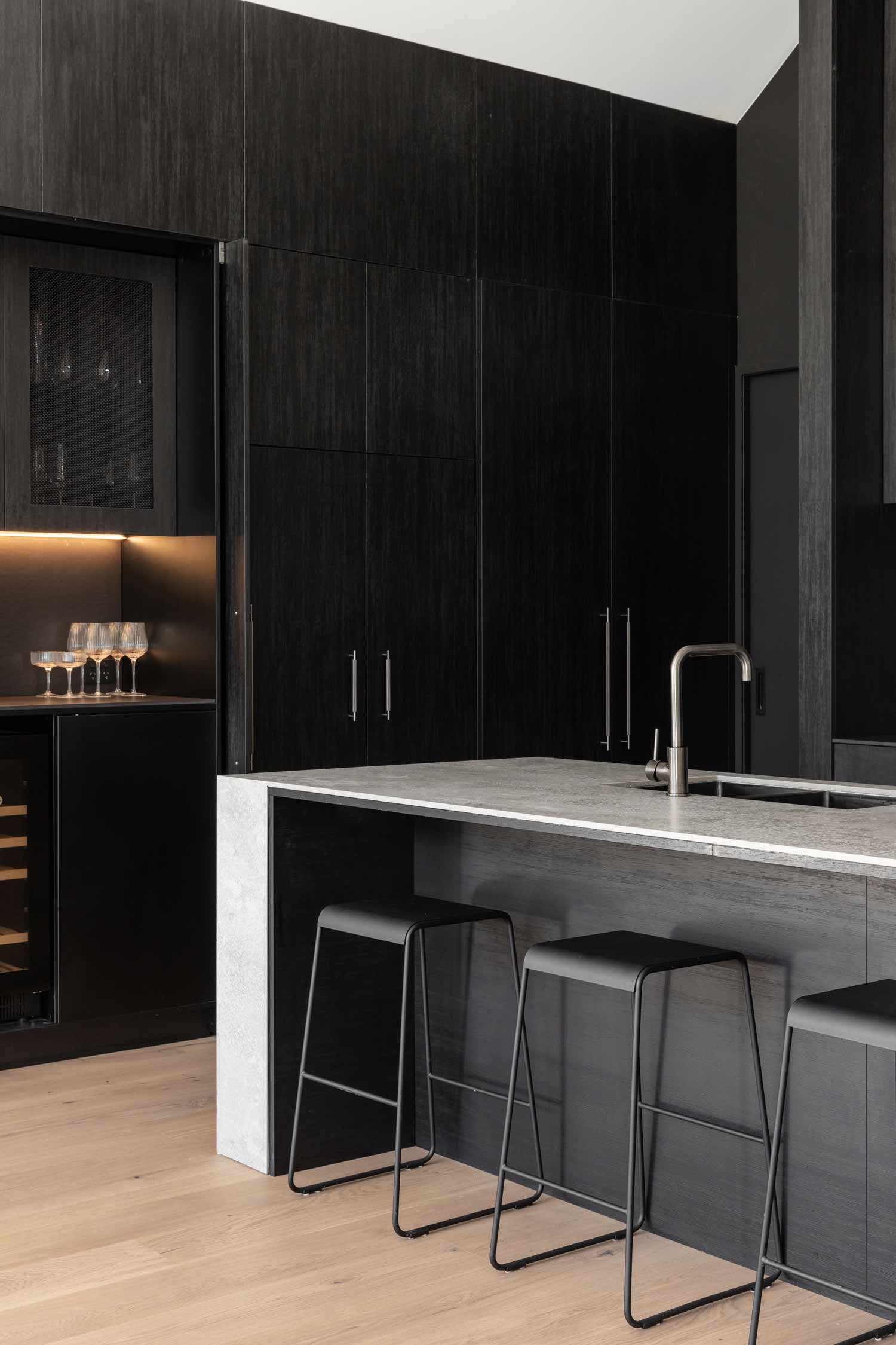 Industrial-dark-kitchen-design-with-stone-benchtop-and-LED-lit-home-bar