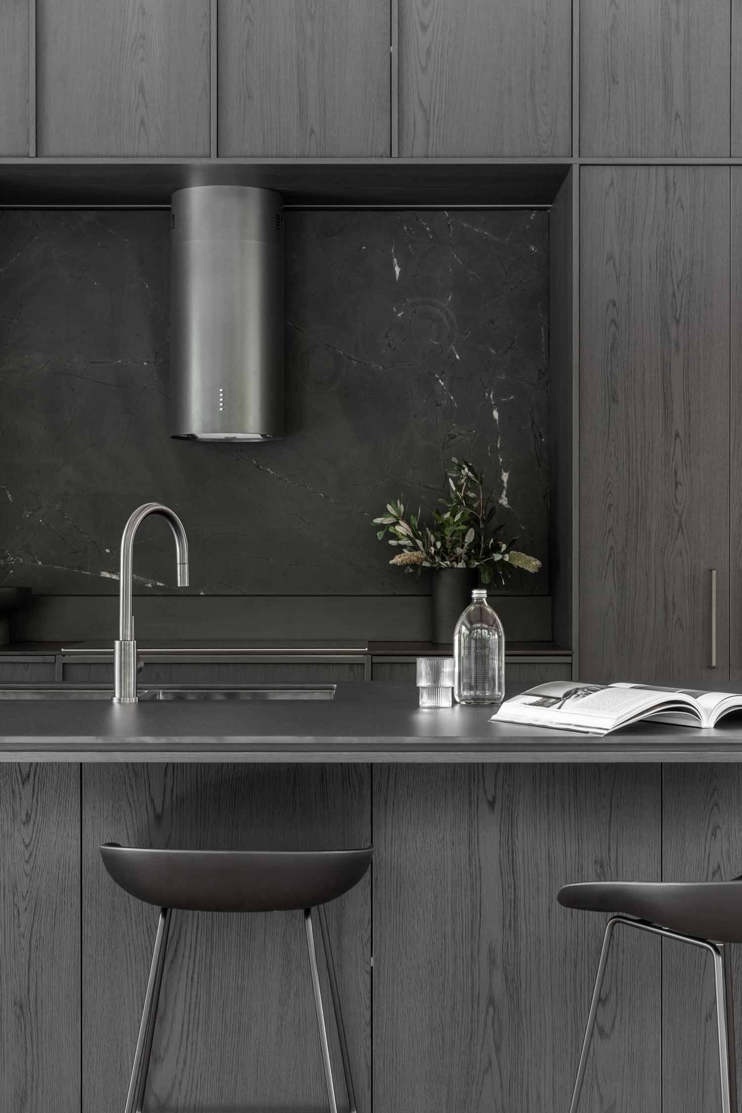 Kooringal-lodge-monochomatic-dark-modern-industrial-style-kitchen-with-black-cabinetry-gunmetal-tapware-and-black-bar-stools