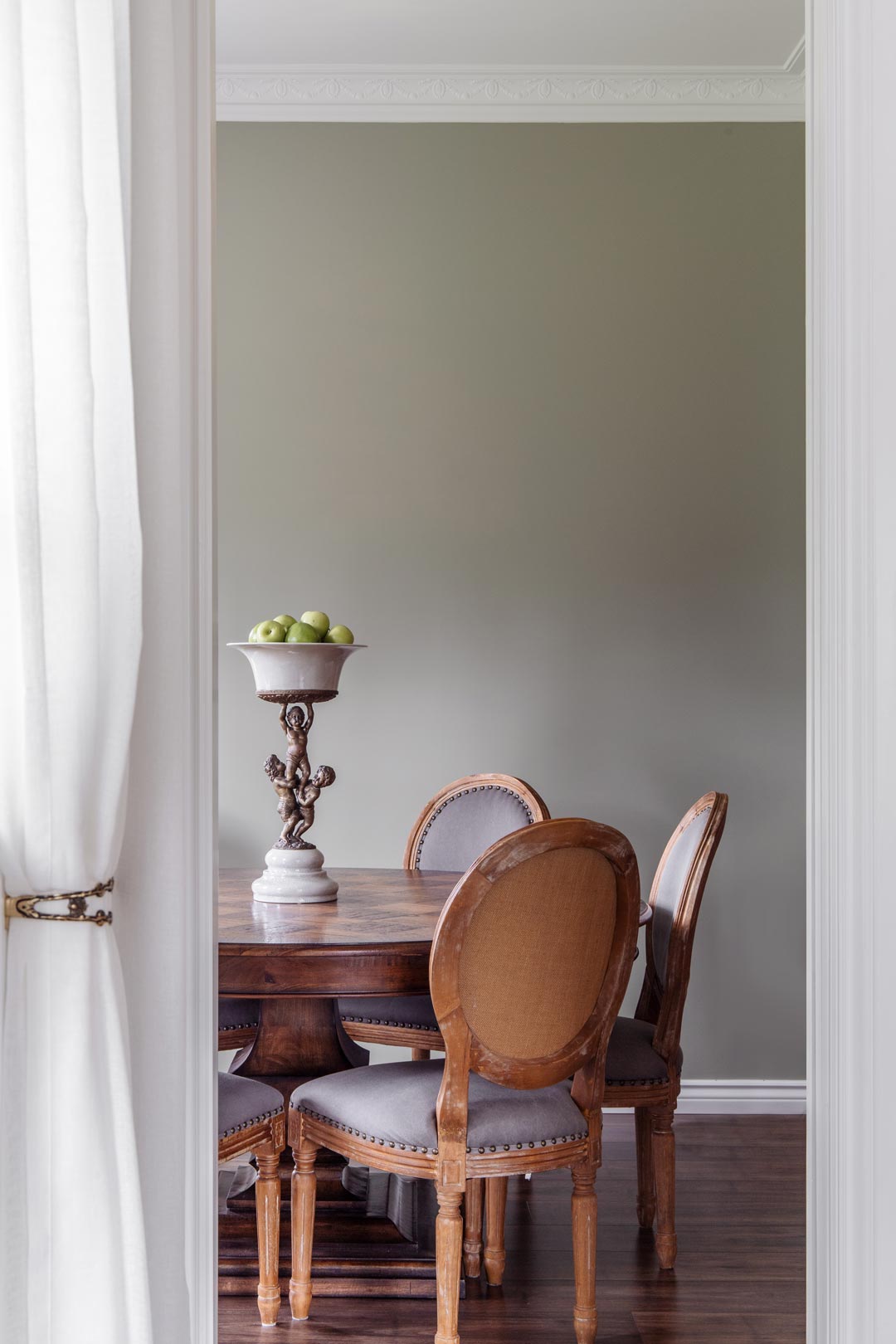 An-old-money-aesthetic-dining-room-with-sage-green-walls-soft-white-sheers-and-worn-vintage-mid-centuary-modern-dining-table-and-chairs