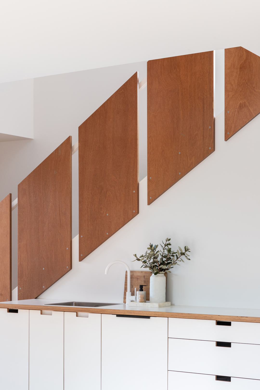 An-architectural-kitchen-design-in-this-New-Zealand-tiny-home-features-different-timber-finishes-white-tapware-and-a-simple-layout