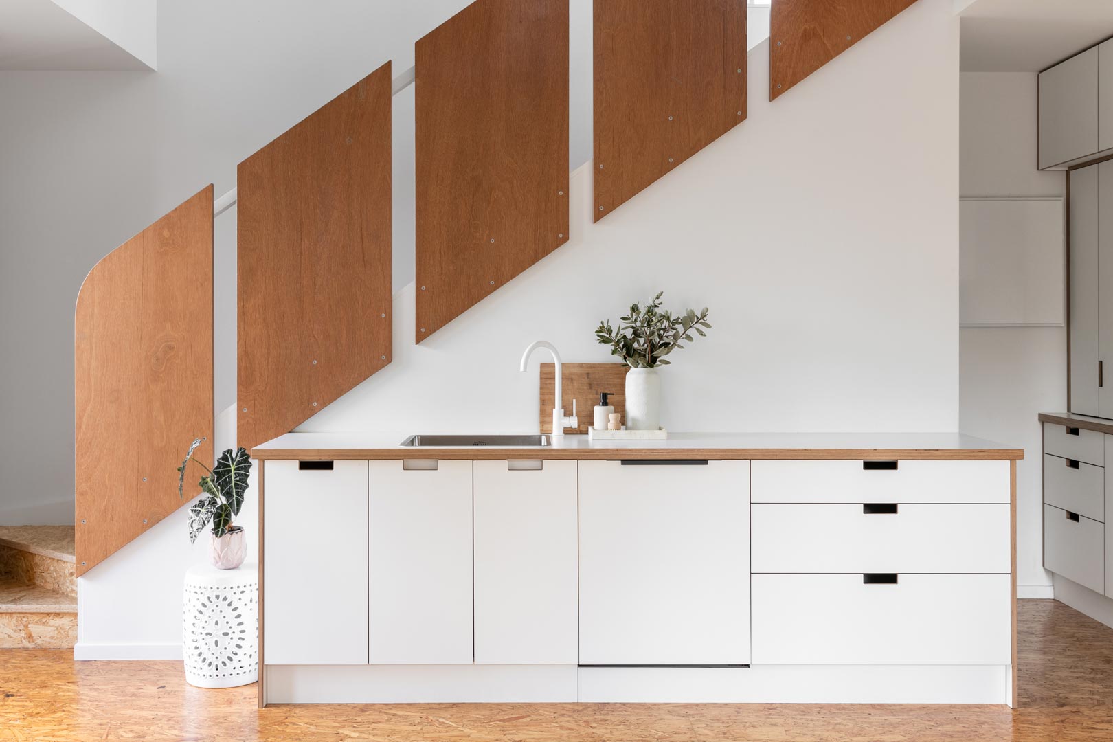 An-architectural-kitchen-design-in-this-tiny-home-features-different-timber-finishes-white-tapware-and-a-simple-layout