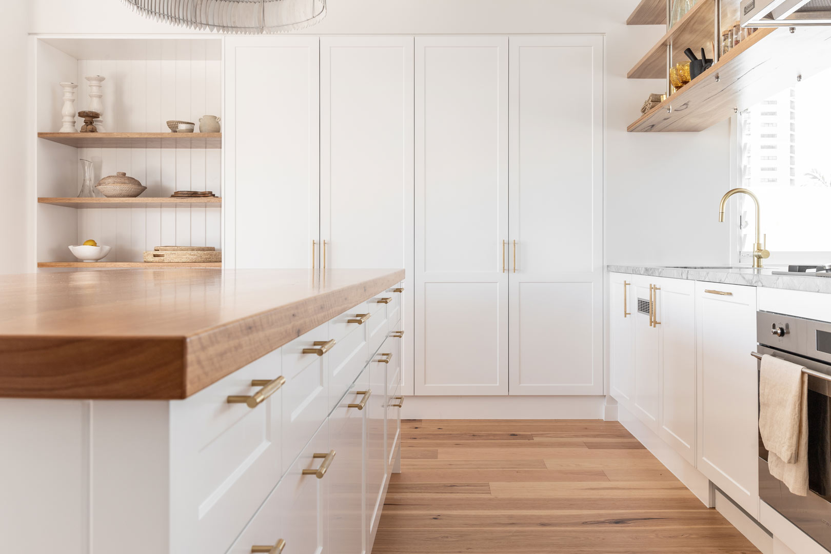 Coastal-open-plan-living-kitchen-with-white-shaker-cabinetry-and-brushed-brass-cabinetry-pulls-1-1
