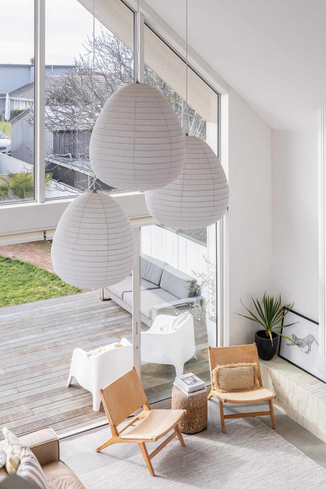 A-void-in-a-modern-barn-style-house-with-floor-to-ceiling-windows-pendant-lights-and-a-pitched-roof