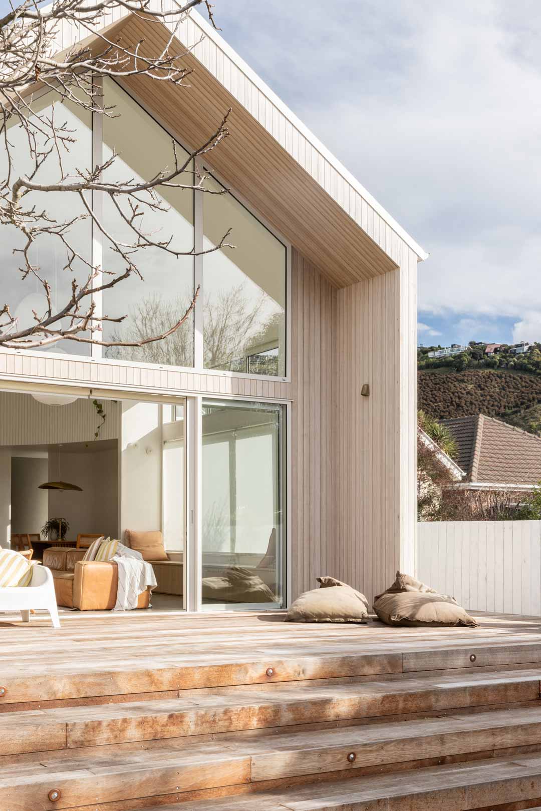 Modern-barn-style-house-with-floor-to-ceiling-windows-sheer-curtains-and-a-pitched-roof