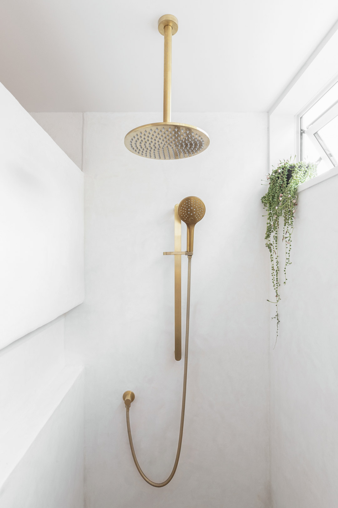 Simple-mediterranean-interior-design-in-this-crisp-shower-with-brushed-brass-tapware
