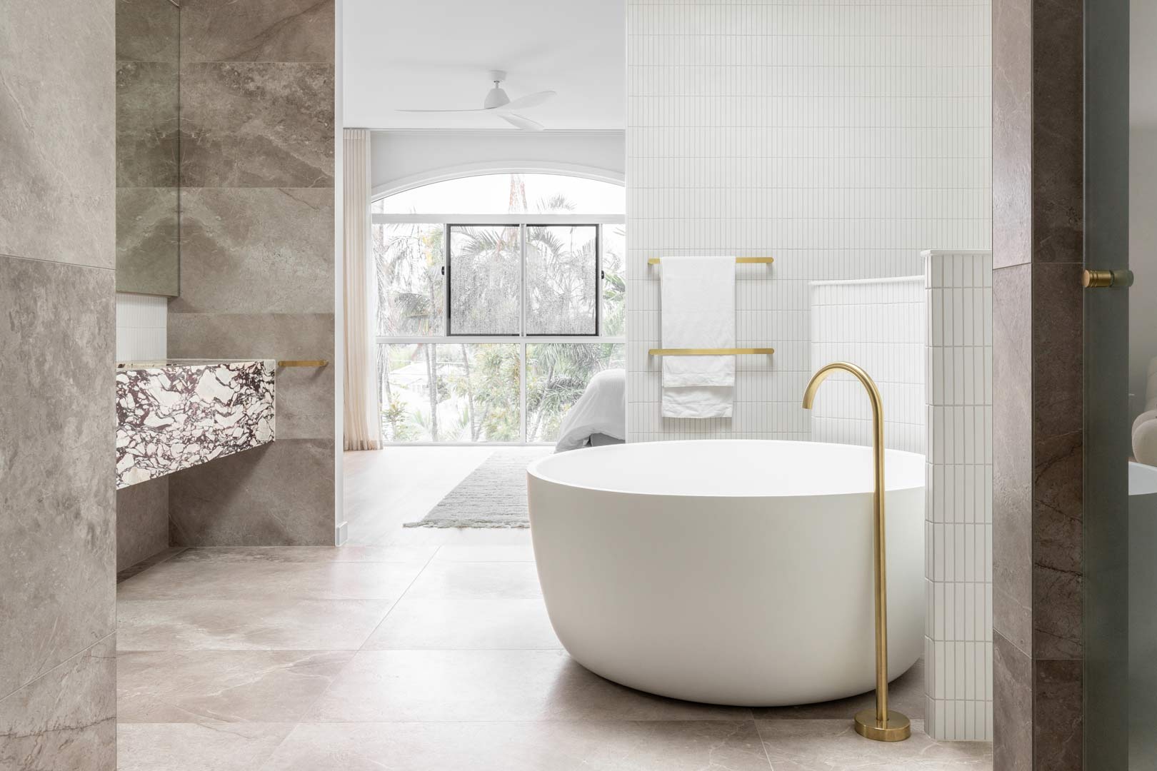 1.-A-neutral-luxurous-ensuite-featuring-brushed-brass-tapware-kit-kat-finger-tiles-and-a-circular-bath