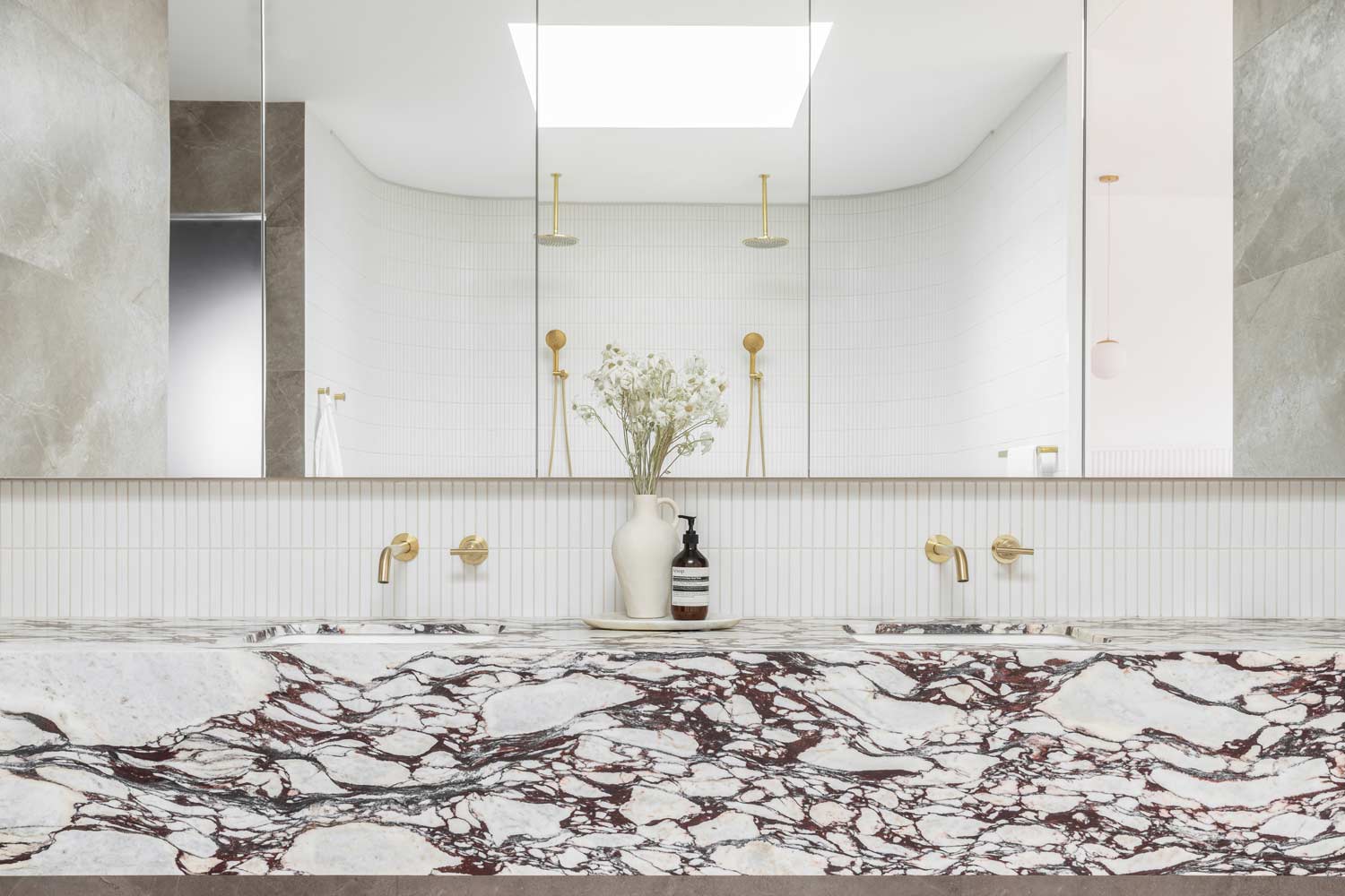 Calacatta-viola-stone-vanity-in-a-neutral-bathroom-with-brushed-brass-tapware