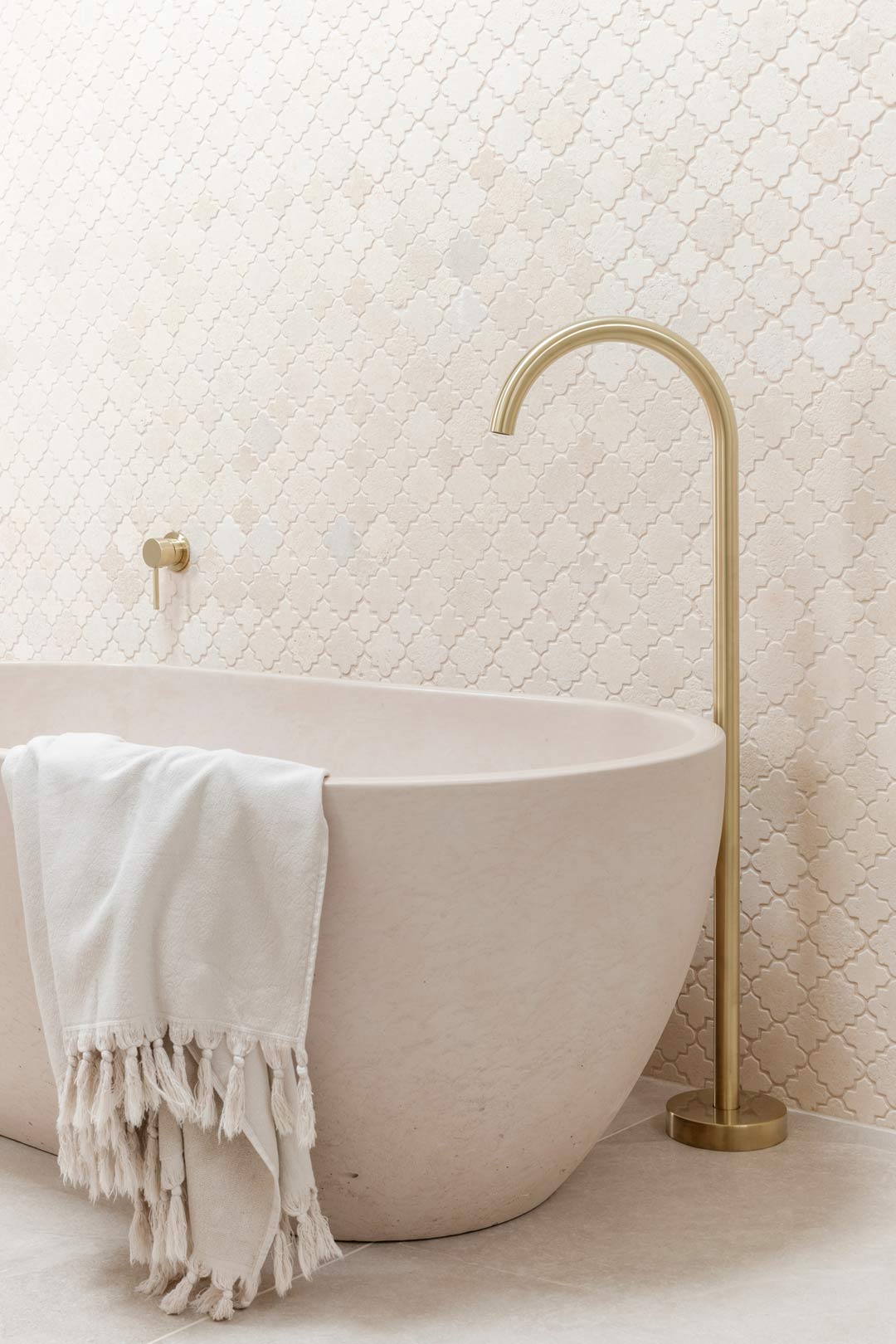 Pastel-pink-bathroom-paired-with-brushed-brass-tapware-and-geometric-feature-tiles