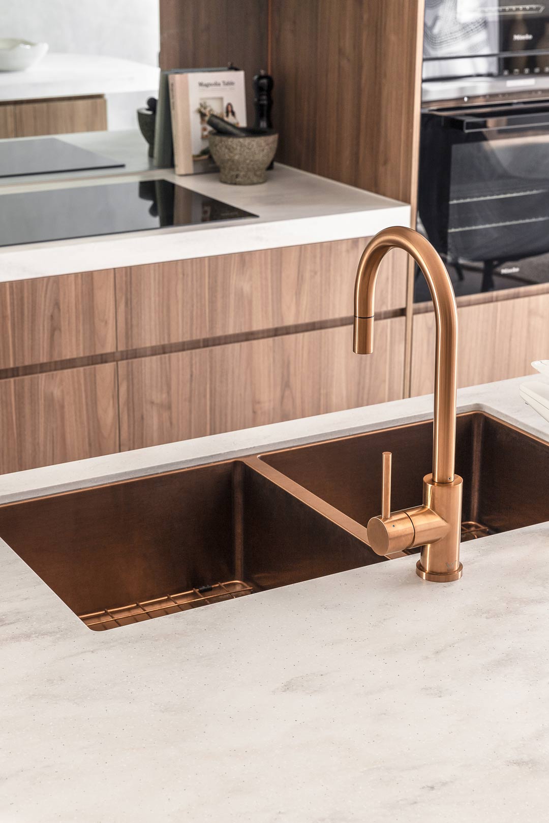 Brushed-copper-tapware-and-matching-double-sink-in-an-industrial-style-kitchen-with-walnut-timber-cabinetry-and-soft-grey-bench-top
