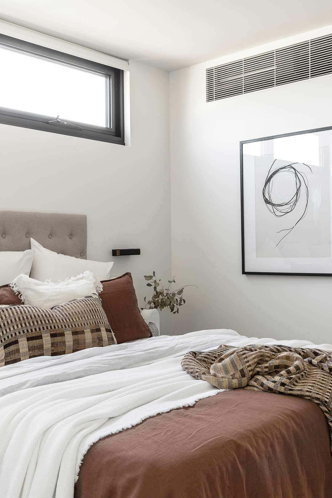 Crisp-white-bed-linen-paired-with-warm-toned-layers-to-create-a-cosy-bedroom