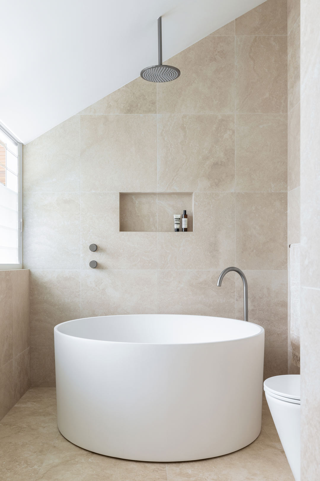 A-clean-and-calm-bathroom-with-brushed-nickel-tapware-and-a-luxurious-round-bath-perfect-for-relaxation-and-self-care